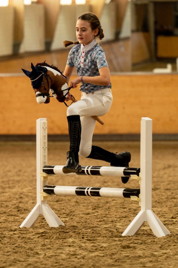 HKM girl jumping over hobby horse jump