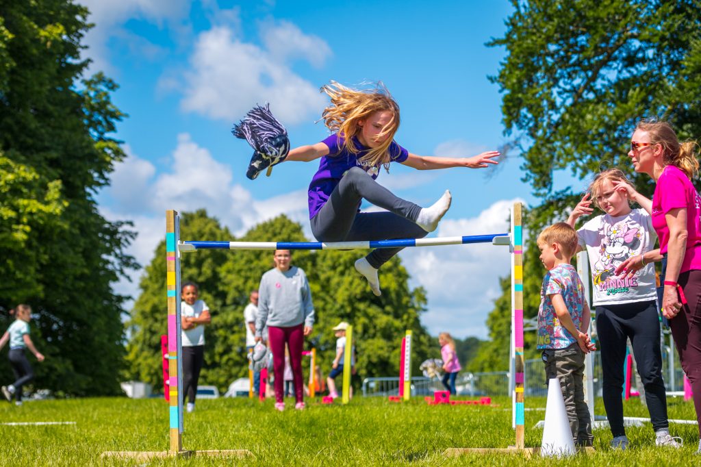 Outdoor pic of El jumpign a hobby horse jump.