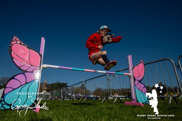 Girl jumps over hobby horse jump