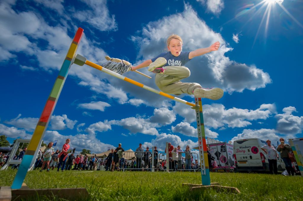Boy jumps over hobby horse