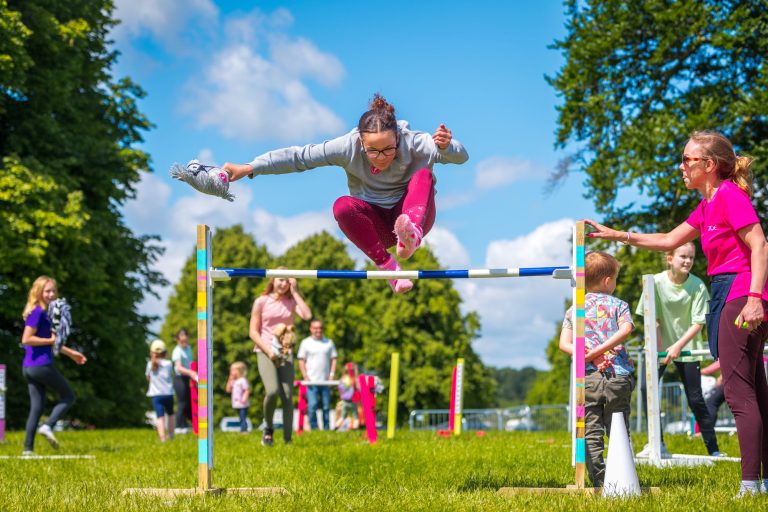 Girl jumping over horse jump
